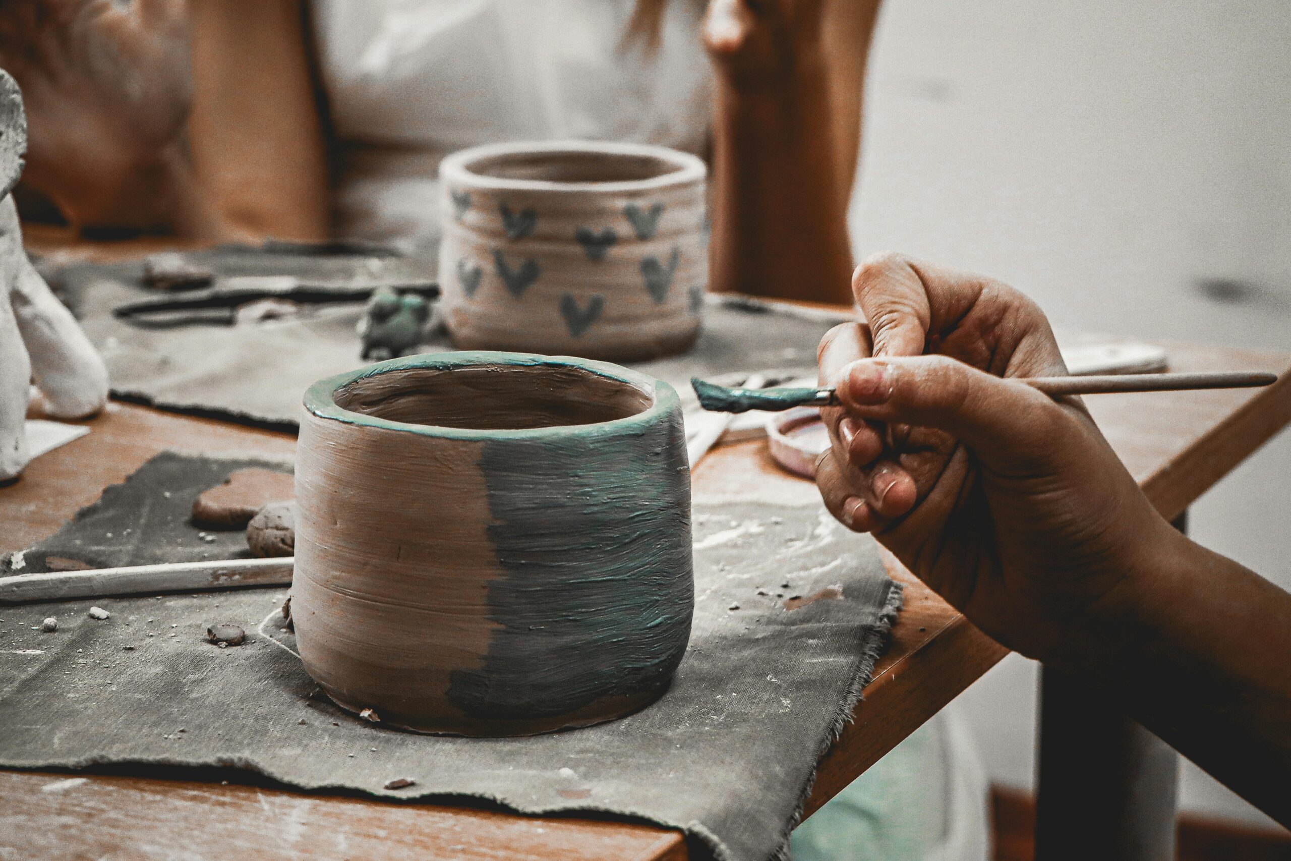 Hands working with clay at a ceramics workshop in Phuket representing one of the popular rainy day activity options