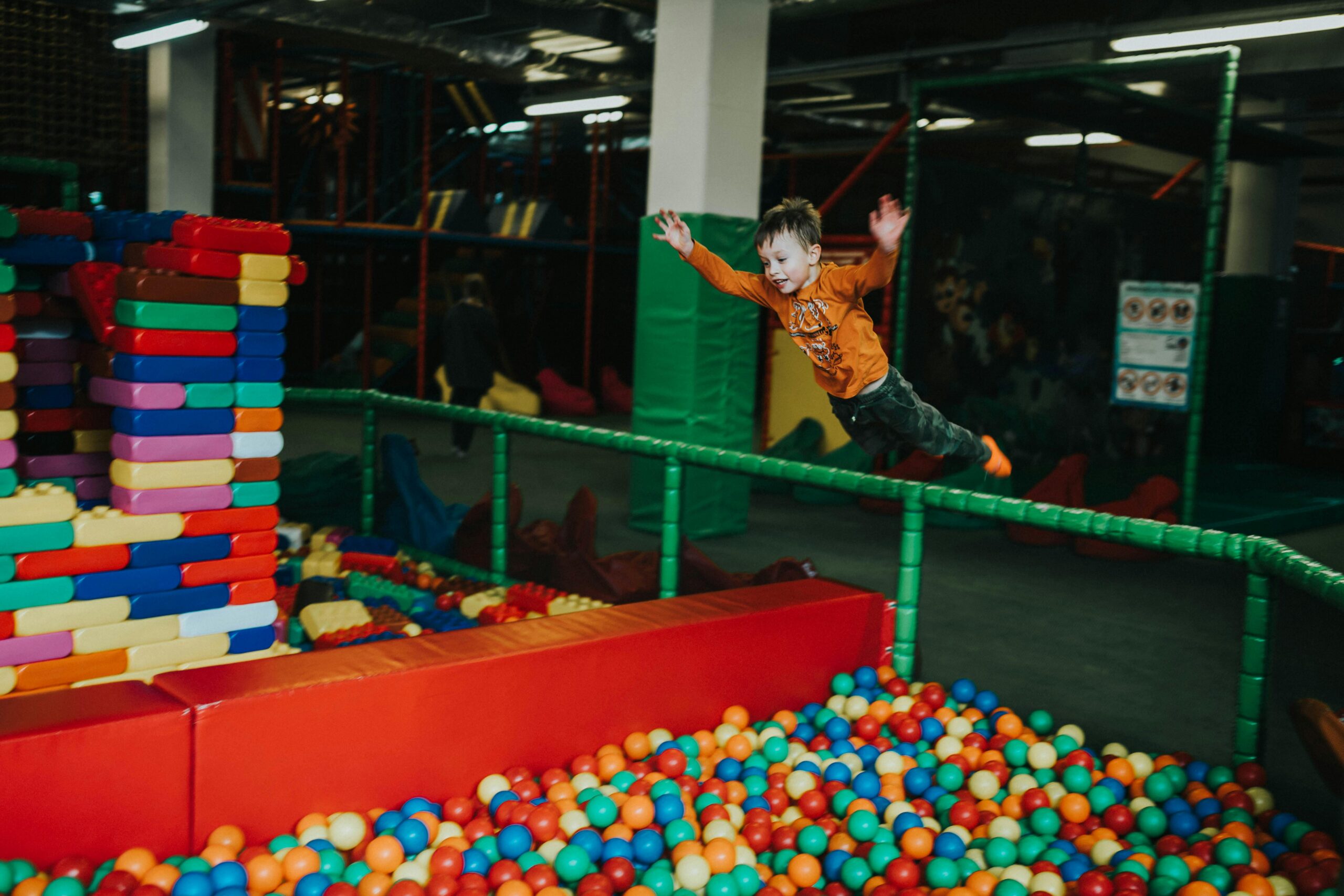 Children playing on trampolines at an indoor activity centre in Phuket on a rainy day